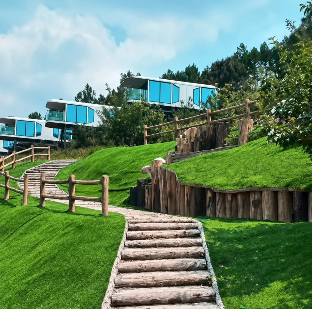 Capsule cabins on hillside with wooden path