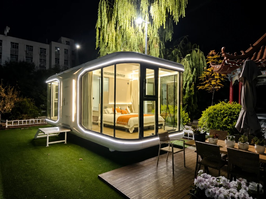 Capsule house glowing on lawn at night